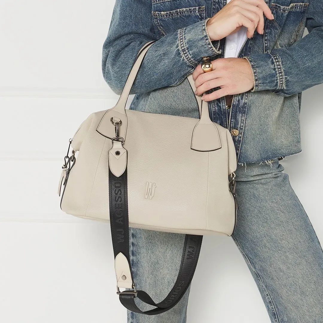 Bolsa de ombro WJ bege sendo usada por modelo com roupa casual jeans